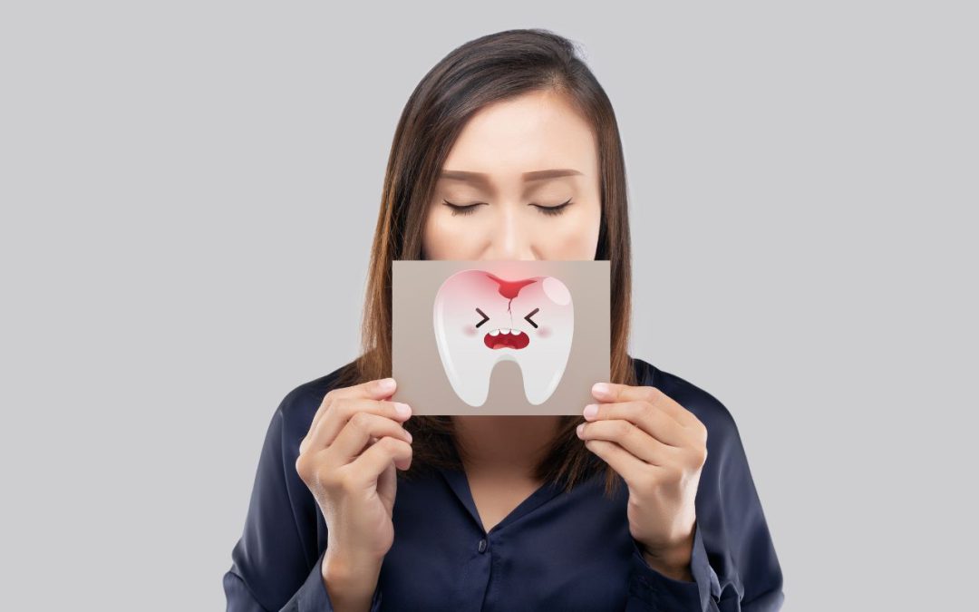 Donna che tiene un'immagine che rappresenta un dente infiammato, simbolo della parodontite, concetto legato alla salute dentale e alla prevenzione orale.