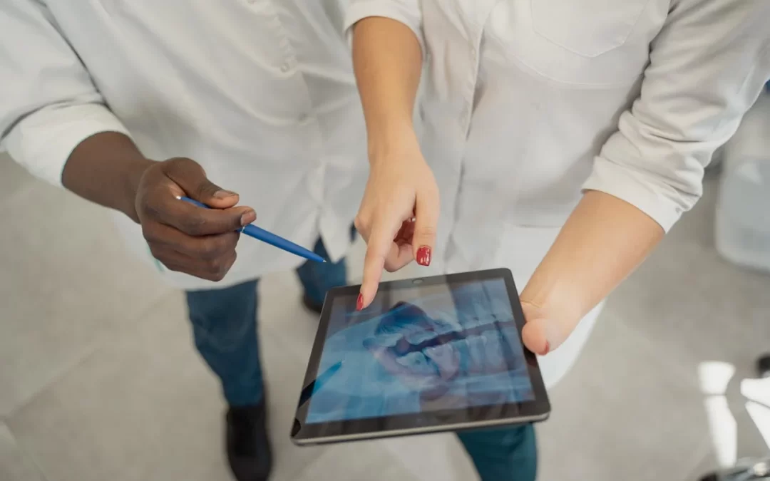 Due dentisti analizzano una radiografia dentale su tablet